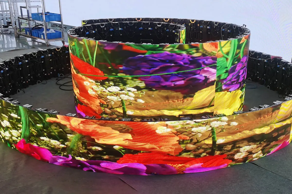 Curved LED video wall arranged in circular sections on a factory floor