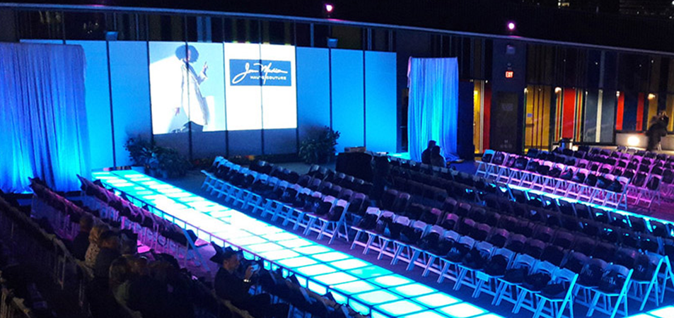 Indoor event runway with illuminated LED stage panels and video backdrop