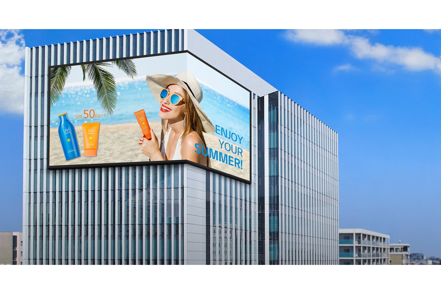 Large outdoor advertisement on a glassy office building showing a woman in a sunhat at the beach with sunscreen bottles and the text Enjoy your summer and SPF 50+